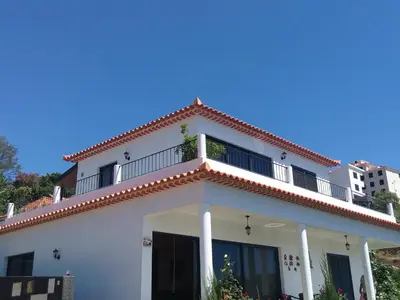 a white house with a balcony on top of it at Casa de Campo in Caniço