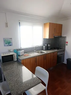 a kitchen with a microwave and a sink and a window at Casa de Campo in Caniço