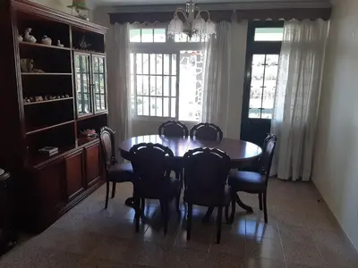 a dining room with a wooden table and chairs at Casa do Terço in Câmara de Lobos