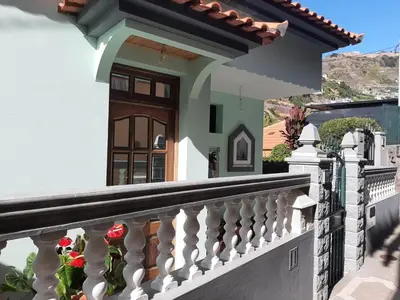 a house with a balcony with roses on it at Casa do Terço in Câmara de Lobos