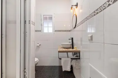 a white bathroom with a sink and a toilet at Sea View Villa by Homie in Santa Cruz