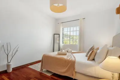 a white bedroom with a bed and a window at Sea View Villa by Homie in Santa Cruz
