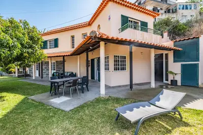 a patio with a table and chairs in front of a house at Sea View Villa by Homie in Santa Cruz