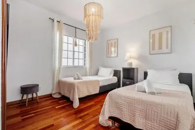a bedroom with two beds and a chandelier at Sea View Villa by Homie in Santa Cruz