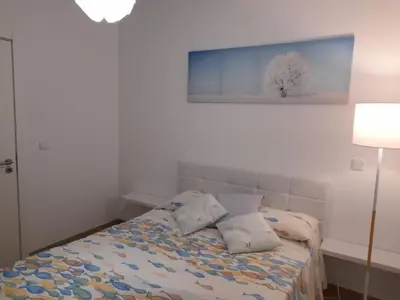 a bedroom with a bed with a blue painting on the wall at Casa Azul in Porto Santo