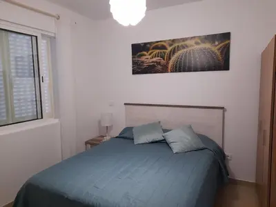 a bedroom with a blue bed and a painting on the wall at Casa Azul in Porto Santo