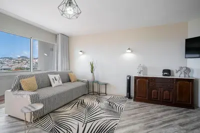 a living room with a couch and a large window at Alegria III by An Island Apart in Funchal