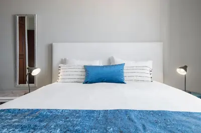 a bedroom with a white bed with blue and white pillows at Alegria III by An Island Apart in Funchal