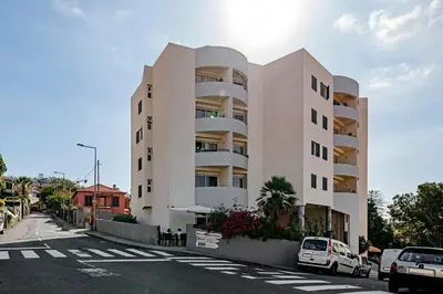 a large white building with cars parked in front of it at Alegria III by An Island Apart in Funchal