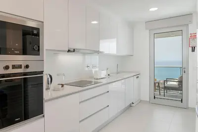 a white kitchen with a view of the ocean at Alameda Formosa I by An Island Apart in Funchal