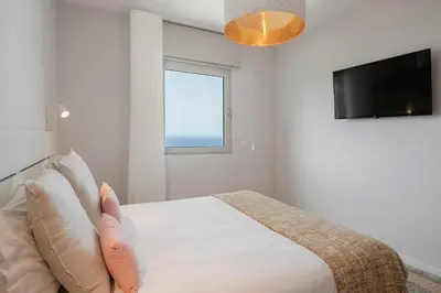 a bedroom with a bed with a window and a tv at Alameda Formosa I by An Island Apart in Funchal