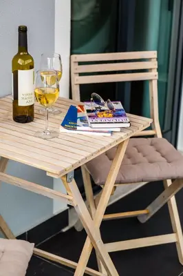 a wooden table with a bottle of wine and a glass at Rose House By Atlantic Holiday in Machico