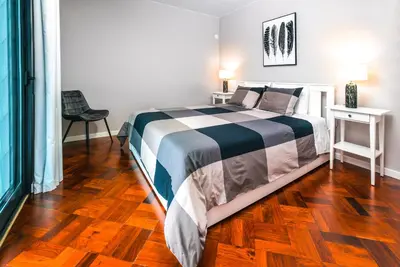 a bedroom with a bed and a wooden floor at Rose House By Atlantic Holiday in Machico