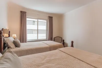 a bedroom with two beds and a window at Residência Costa do Sol in Funchal