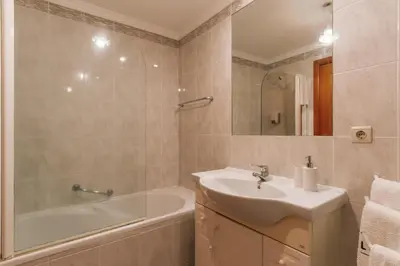 a bathroom with a sink and a bath tub and a sink at Residência Costa do Sol in Funchal