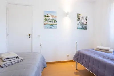 two beds in a room with white walls at Sea Blue Apartment - Luz Ocean Club in Luz