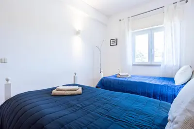 a bedroom with two blue beds and a window at Sea Blue Apartment - Luz Ocean Club in Luz