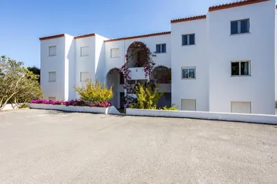 a large white building with flowers in the driveway at Sea Blue Apartment - Luz Ocean Club in Luz