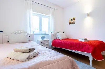 two beds in a bedroom with a red blanket at Sea Blue Apartment - Luz Ocean Club in Luz