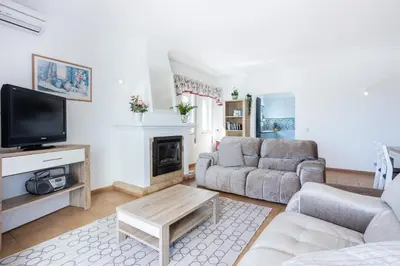 a living room with a couch and a tv at Sea Blue Apartment - Luz Ocean Club in Luz