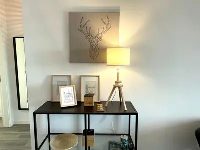 a table with a lamp and pictures on a wall at Ocean Cliff Apartment in Santa Cruz