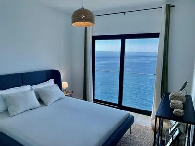 a bedroom with a bed with a view of the ocean at Ocean Cliff Apartment in Santa Cruz
