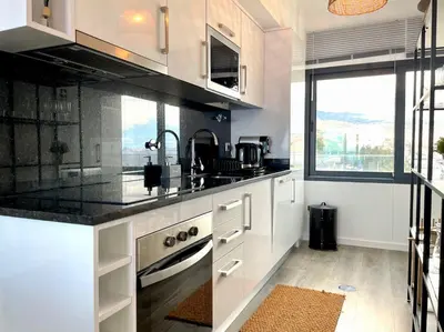 a kitchen with white cabinets and a sink at Ocean Cliff Apartment in Santa Cruz