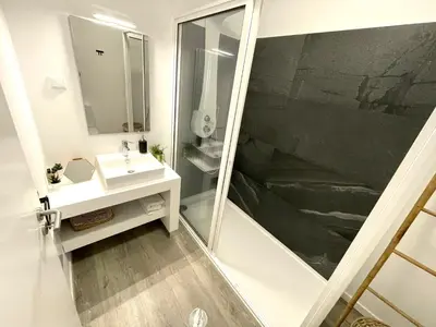 a bathroom with a sink and a shower with a mirror at Ocean Cliff Apartment in Santa Cruz