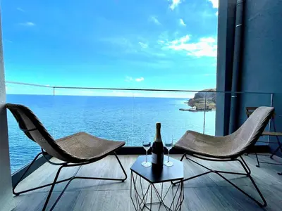 two chairs and a table with a bottle of wine at Ocean Cliff Apartment in Santa Cruz
