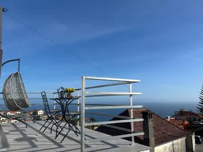 a table with an umbrella and chairs and a table with bananas at Isabela House in Ponta do Sol