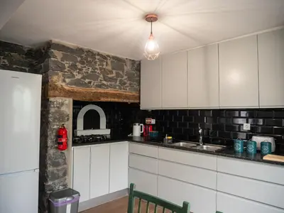 a kitchen with a wooden table with chairs and a tableasteryasteryasteryasteryastery at Isabela House in Ponta do Sol