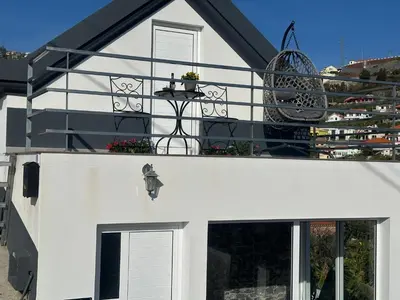 a white house with a staircase leading up to the door at Isabela House in Ponta do Sol