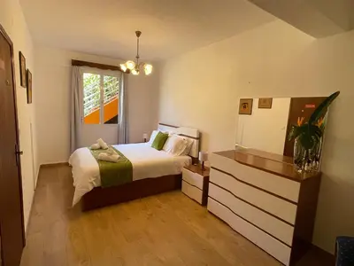 a bedroom with a bed and a dresser and a window at Sunset House in Arco da Calheta