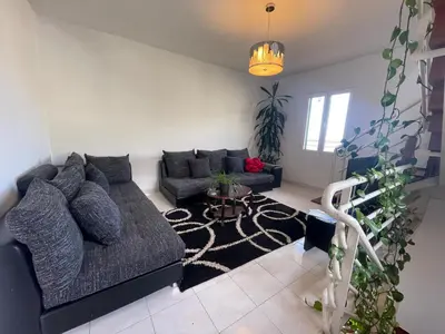 a living room with a couch and a table at Sunset House in Arco da Calheta