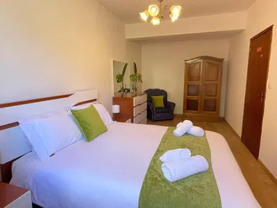 a bedroom with a large white bed with towels on it at Sunset House in Arco da Calheta