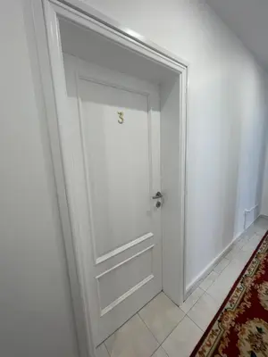 a white door in a room with a rug at Sunset House in Arco da Calheta