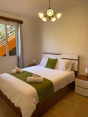 a bedroom with a large bed with towels on it at Sunset House in Arco da Calheta