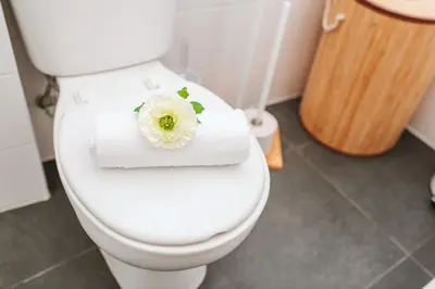 a white toilet with a white flower on the lid at The Millennial Lifestyle Apartment by Amazing Madeira in Funchal