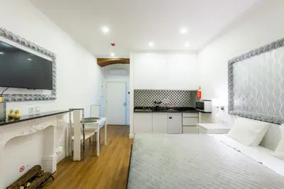 a kitchen with white walls and a living room at Le Vingale in Funchal