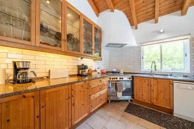 a large kitchen with wooden cabinets and a sink at Casa Garrod - Spacious Family Villa in Aljezur