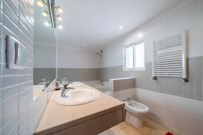 a white bathroom with a sink and a toilet at Casa Garrod - Spacious Family Villa in Aljezur