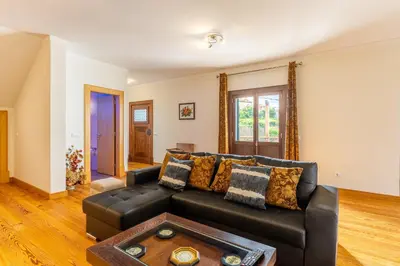 a living room with a black leather couch at Villa Dinis by Holiday Rental Madeira in Calheta