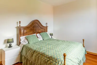 a bedroom with a bed with a green comforter at Villa Dinis by Holiday Rental Madeira in Calheta