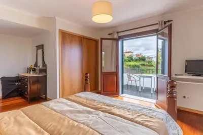 a bedroom with a bed and a balcony at Villa Dinis by Holiday Rental Madeira in Calheta