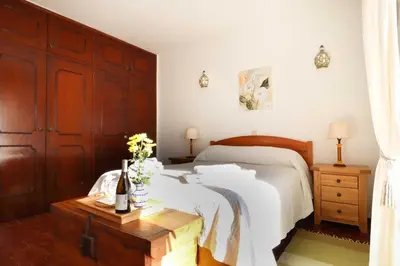 a bedroom with a bed and a table with a bottle of wine at 3B Waterside in Luz