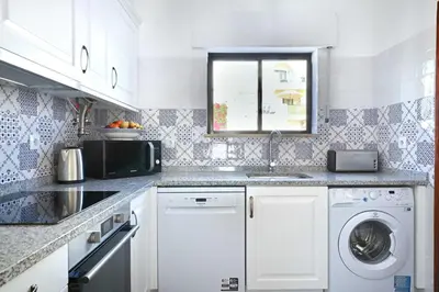 a kitchen with a sink and a washing machine at 3B Waterside in Luz