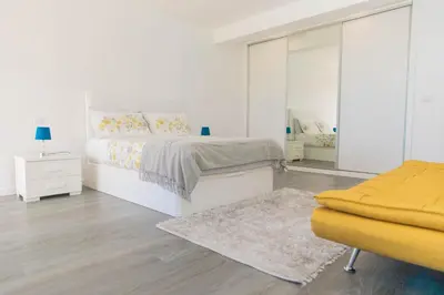 a white bedroom with a bed and a mirror at House - sleeps 3 free parking garden & jacuzzi in Estreito da Calheta