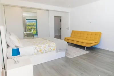a bedroom with a yellow bed and a mirror at House - sleeps 3 free parking garden & jacuzzi in Estreito da Calheta