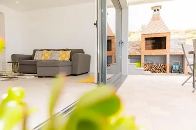 a living room with a couch and a patio at House - sleeps 3 free parking garden & jacuzzi in Estreito da Calheta