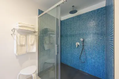 a bathroom with a shower with blue tiles at Casa Amarela Apartments - by Casas na Ilha in Câmara de Lobos